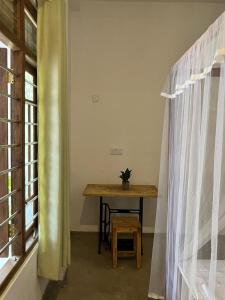 a table with a potted plant on it next to a window at HideWay Guest House Midigama in Midigama East