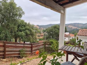 a porch with a wooden fence and a bench at Studio in peaceful village of São Martinho das Amoreiras in São Martinho das Amoreiras