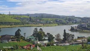 a view of a river with houses and a town at Ru Hotel & Villa in Nuwara Eliya