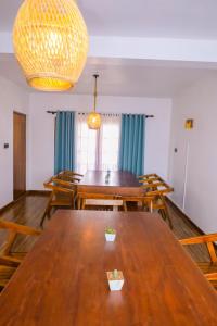 a dining room with a large wooden table and chairs at Ru Hotel & Villa in Nuwara Eliya