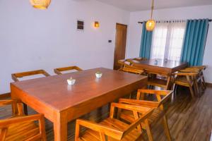 a dining room with wooden tables and chairs at Ru Hotel & Villa in Nuwara Eliya +33 photos