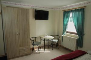 a room with a table and chairs and a window at Pension Schiffer in Blankenheim