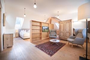 a living room with two chairs and a bed at Hotel Kabis in Funes