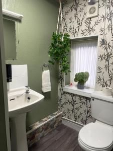 a bathroom with a sink and a toilet and a window at The Black Swan Inn in Leominster +50 photos