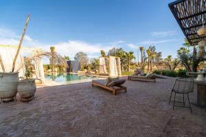 a patio with a pool with chairs and a table at VILLA 2s in Marrakesh