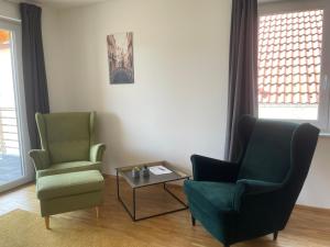 a living room with two chairs and a coffee table at Art Apart Stuttgart in Rutesheim