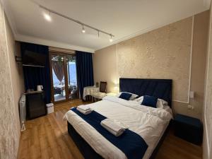 a bedroom with a large bed with blue and white sheets at Sunny Village Hotel in Haghpat