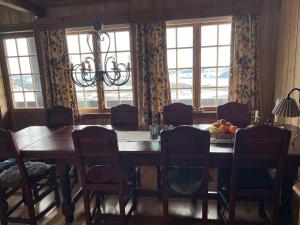 a dining room with a table and chairs and windows at Bjødnabakkvegen 22C in Beitostøl +10 photos