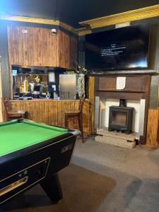 a pool table in a room with a fireplace at The Black Swan Inn in Leominster