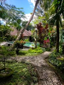 a path leading to a resort with a swimming pool at Sang Fajar Ubud in Ubud