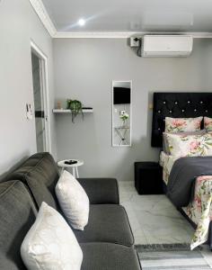 a living room with a couch and a bed at Roxy's in Richards Bay