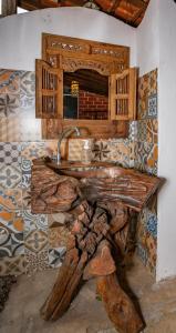 a kitchen with a wooden counter with a sink at Ganesh Chalés in Boracéia