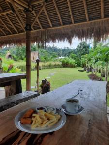 Ein Teller Pommes frites und eine Tasse Kaffee auf einem Tisch in der Unterkunft Uma Buug in Karangasem