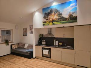 eine Küche mit einem Sofa und einem Fernseher an der Wand in der Unterkunft Herzplatz in Altötting
