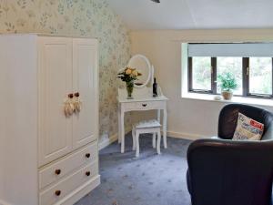 a room with a dresser and a table with a chair at Rosecraddoc Manor - Hayloft in Saint Cleer