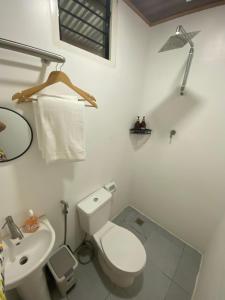 a white bathroom with a toilet and a sink at L & Ev Be My Guest in San Juan