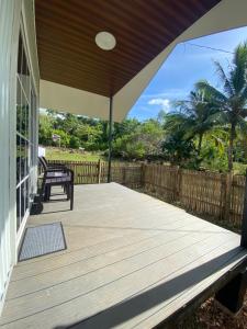 a wooden deck with a bench on a house at L & Ev Be My Guest in San Juan