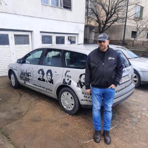 a man is standing in front of a car at AGAPE in Leskovac