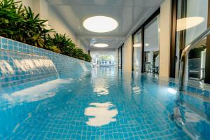 a swimming pool with a blue tiled floor at Bailey Hotel Hue in Hue