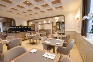 a restaurant with tables and chairs and a counter at Hotel Europa in Taranto