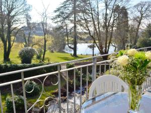 a table with a vase of flowers on a balcony at Rosecraddoc Manor - Riverview in Saint Cleer +12 photos