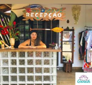 a woman standing behind a counter in a store at Ganesh Chalés in Boracéia