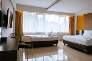 a hotel room with two beds and a window at Siesta Legian in Legian