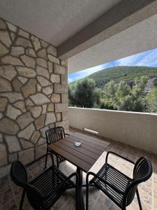 a patio with a table and two chairs and a large window at Spa&Hotel Studenac in Trebinje