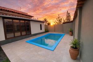 a swimming pool in the backyard of a house at Meu Point Gravatá 1 - Refúgio Familiar a 100 Metros do Mar in Saquarema