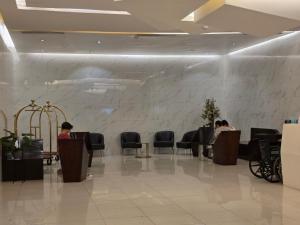 a lobby with people sitting at tables and chairs at Apartment 2 Quezon City Condo Pool View in Manila +37 photos