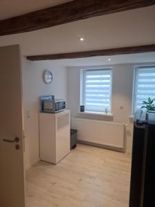 a living room with a microwave and two windows at Ferienwohnung Alte Glaserei in Ilsenburg +6 photos
