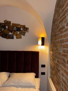 a bedroom with a bed and a brick wall at RotHaus Old Town Sibiu in Sibiu