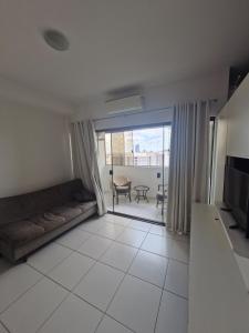 a living room with a couch and a table at Flat com 1 quarto e sala in Goiânia