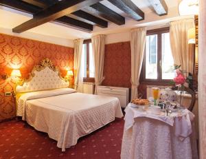 a bedroom with a bed and a table with food on it at Ca' Della Loggia in Venice