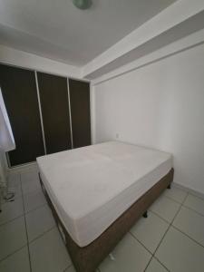 a bedroom with a bed in the corner of a room at Flat com 1 quarto e sala in Goiânia +10 photos