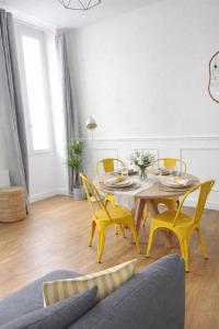a dining room with a table and yellow chairs at Appartement Marseille au cœur du panier in Marseille