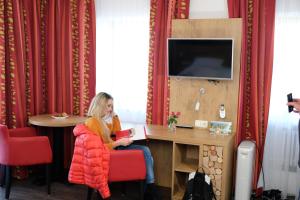 a woman sitting at a table in a room at Hotel Seiserhof & Seiseralm in Bernau am Chiemsee