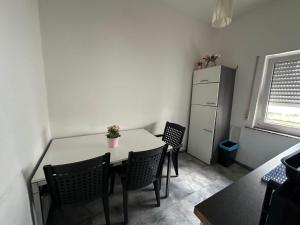 a kitchen with a table and chairs and a refrigerator at Frankfurt Airport & Fair Apartment in Kelsterbach