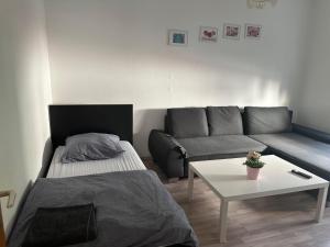 a living room with a bed and a couch at Frankfurt Airport & Fair Apartment in Kelsterbach
