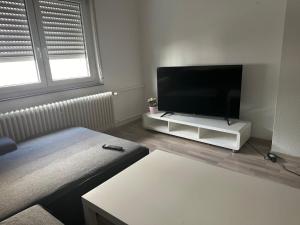 a living room with a flat screen tv on a stand at Frankfurt Airport & Fair Apartment in Kelsterbach