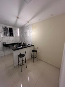 a kitchen with two bar stools and a counter at Loftt concept in Rio de Janeiro