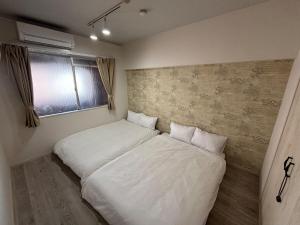 a small bedroom with a bed with white sheets at HOTTOSTAYman401 in Sasashimachō