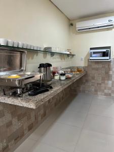 a kitchen with a counter with food on it at Prado Hotel in Salgueiro