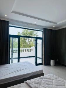 a bedroom with a large bed and a large window at Signature in Ấp Vĩnh Lạc