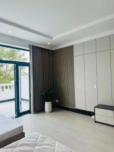a bedroom with a bed and a large sliding glass door at Signature in Ấp Vĩnh Lạc