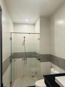 a bathroom with a glass shower with a toilet at Signature in Ấp Vĩnh Lạc