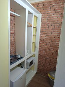 a kitchen with a brick wall and a microwave at Wonderland Villa Tierra Fértil Los Gigantes in Santiago del Teide +54 photos