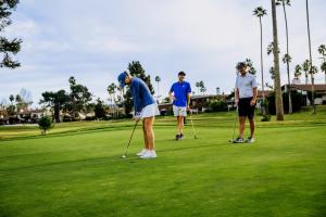 three people playing golf on a golf course at Guesthouse Hotel at La Valle in Rancho Santa Fe