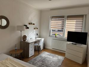 a bedroom with a desk and a bed with a television at Ferienwohnung Chiara in Mettlach