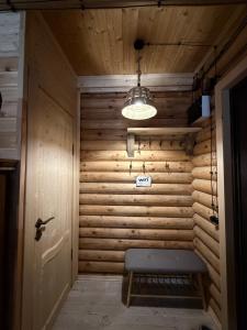 a room with a wooden wall with a bench and a light at Birtvisi Dream House in Abrameti